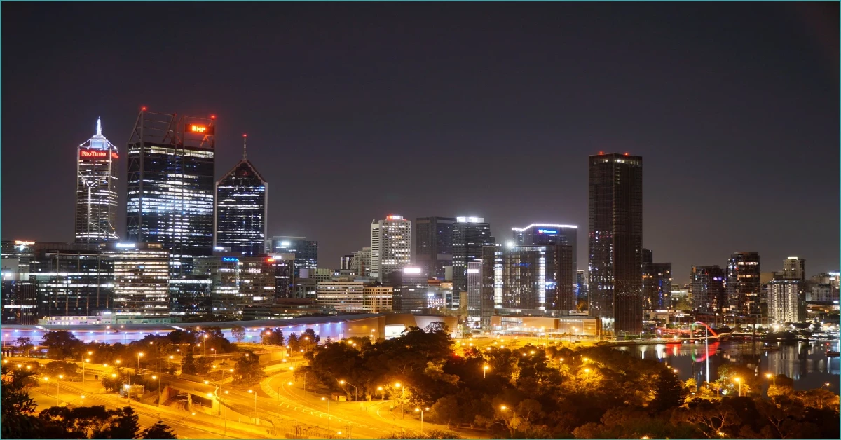 Perth city skyline at night, illuminated buildings.