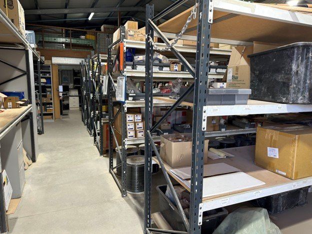 A warehouse aisle with shelving filled with various boxes and items.