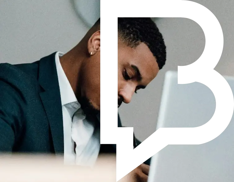A person in a suit working on a laptop.