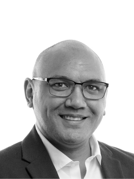 Heemi, team member at Bidbuddy, smiling in a professional black and white portrait.