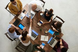 Top-down view of a professional team collaborating around a table — featured image for article on tender writing best practices.